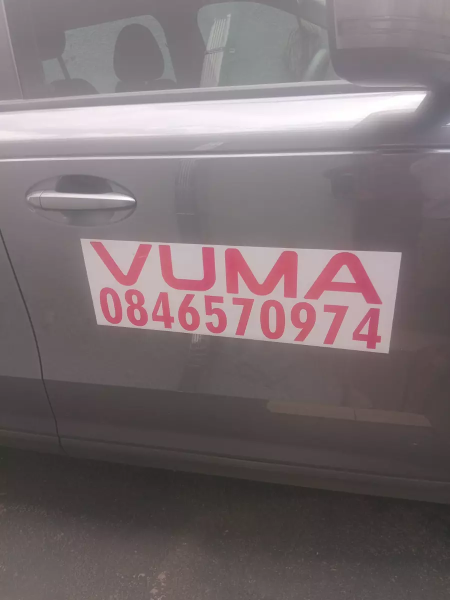 Grey car door with Vuma business branding and phone number